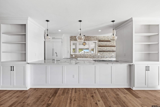 bar with light stone counters, black electric stovetop, white cabinetry, paneled built in refrigerator, and light hardwood / wood-style flooring