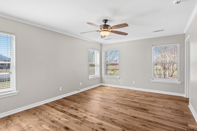 unfurnished room with ornamental molding, a wealth of natural light, hardwood / wood-style flooring, and ceiling fan