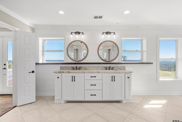 bathroom featuring vanity, a healthy amount of sunlight, and crown molding