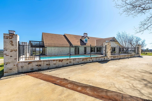 rear view of house featuring an empty pool and a patio area