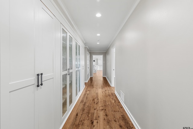 corridor featuring wood-type flooring and crown molding