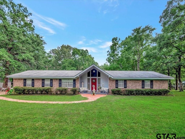 ranch-style home featuring brick siding and a front lawn