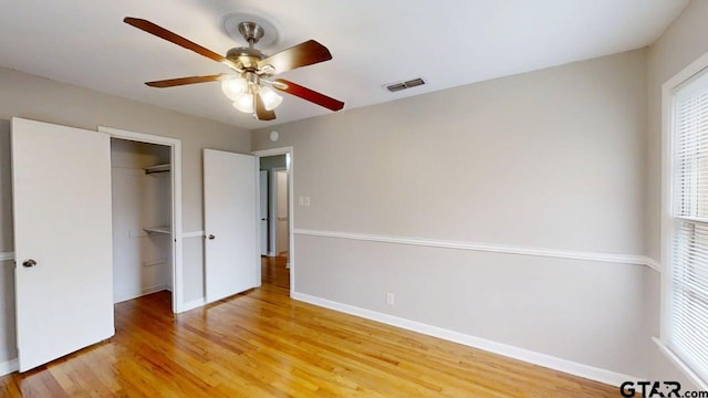 unfurnished bedroom featuring baseboards, visible vents, a closet, and light wood-type flooring