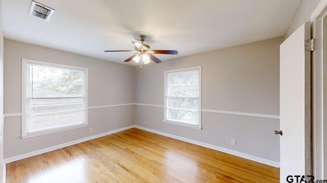 unfurnished room with baseboards, visible vents, light wood-style flooring, and a ceiling fan