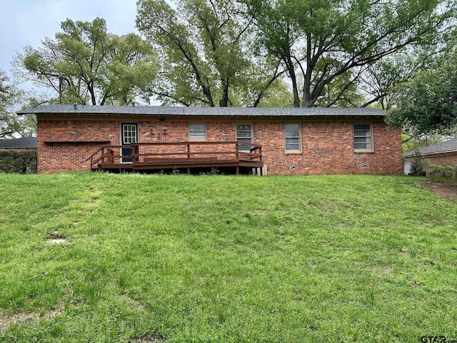 back of property with a lawn, a deck, and brick siding