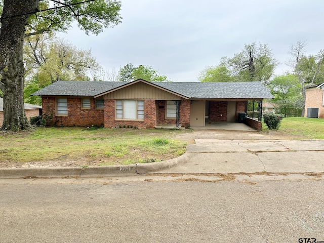 ranch-style house featuring central air condition unit, a front yard, a carport, and brick siding