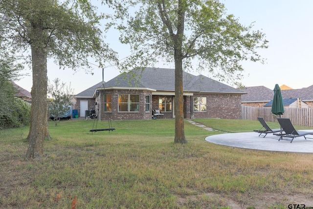 rear view of house featuring a lawn and a patio area