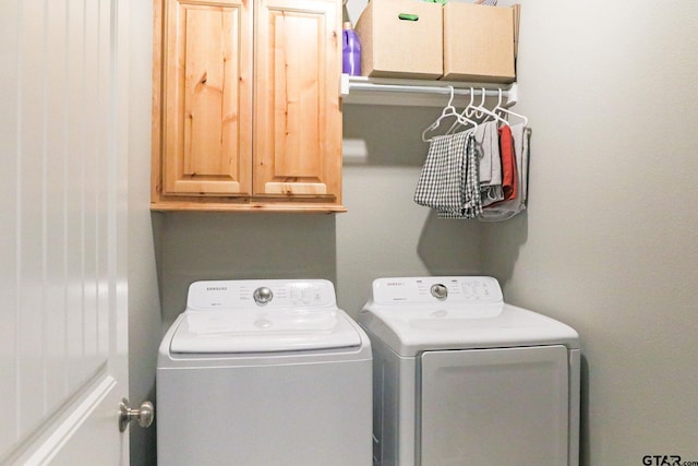 laundry room featuring washing machine and dryer and cabinets