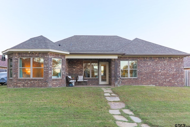 rear view of property featuring a yard