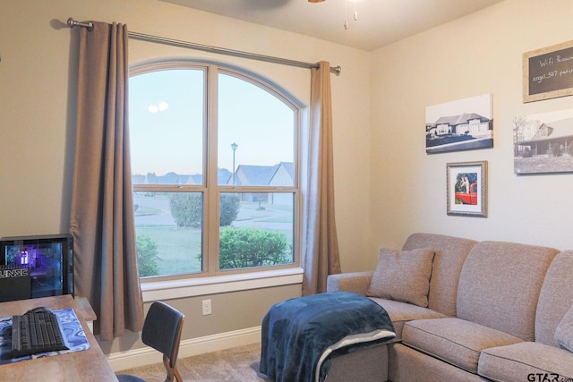 living room featuring plenty of natural light, ceiling fan, and light carpet