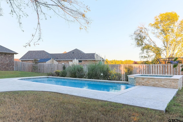 view of swimming pool featuring an in ground hot tub and a yard