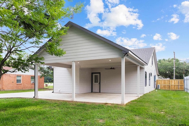 back of property featuring ceiling fan, a patio, and a yard