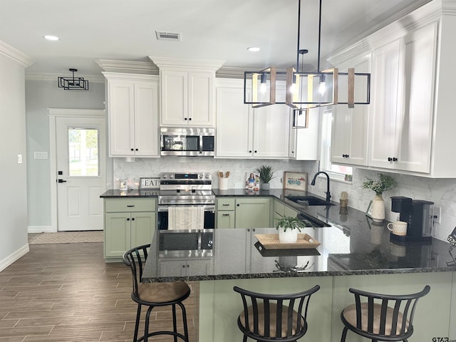 kitchen with crown molding, stainless steel appliances, white cabinetry, dark hardwood / wood-style flooring, and sink