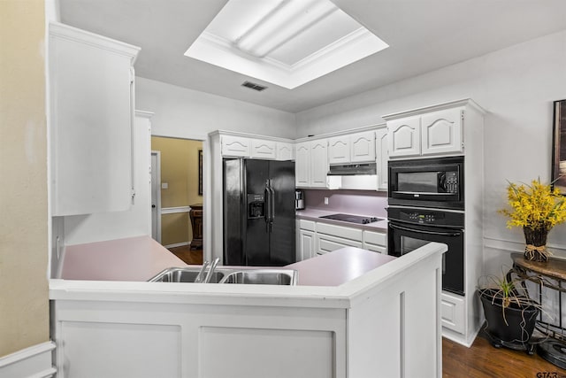 1737 Bearwood Ln, Tyler, TX 75703 - kitchen with black appliances, a sink, a peninsula, white cabinets, and dark wood-type flooring