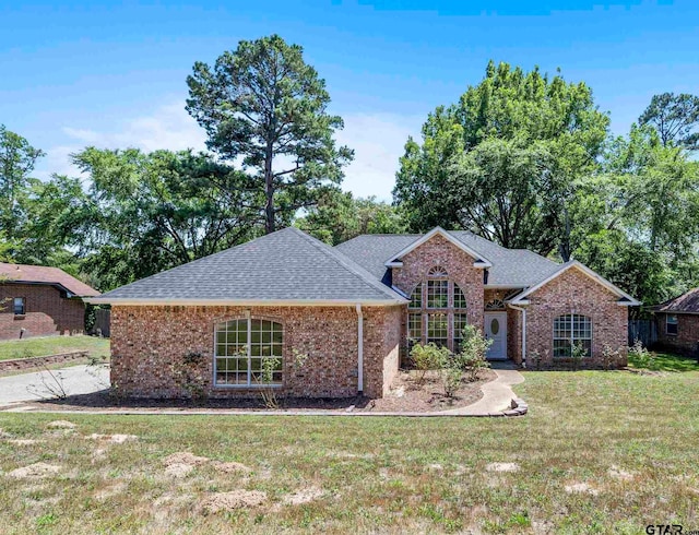 1737 Bearwood Ln, Tyler, TX 75703 - single story home featuring a shingled roof, a front lawn, and brick siding