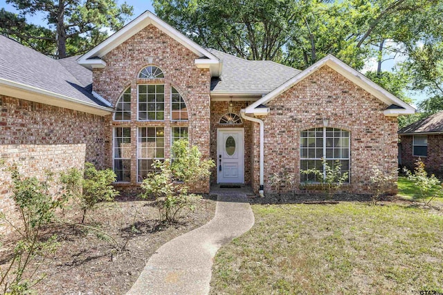 1737 Bearwood Ln, Tyler, TX 75703 - view of front facade featuring brick siding, roof with shingles, and a front lawn