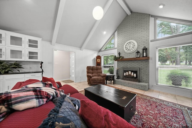 living room featuring a fireplace, beam ceiling, light tile patterned floors, and high vaulted ceiling