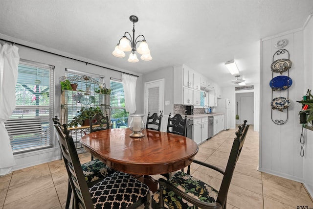 tiled dining room featuring sink and an inviting chandelier