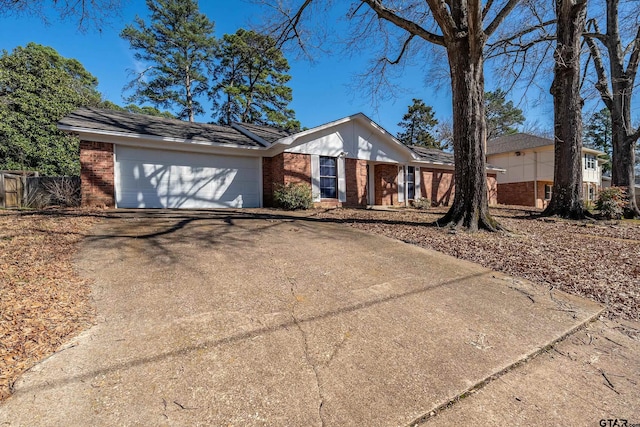 ranch-style house with driveway, a garage, fence, and brick siding