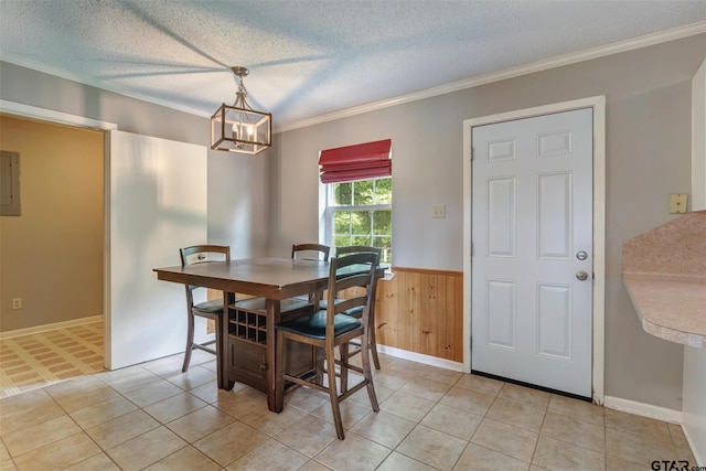 dining area with a textured ceiling, electric panel, crown molding, and wooden walls