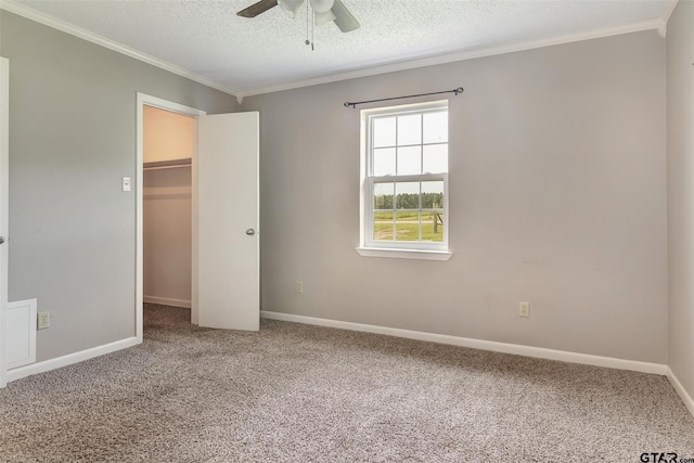 unfurnished bedroom featuring a textured ceiling, carpet floors, ceiling fan, and ornamental molding