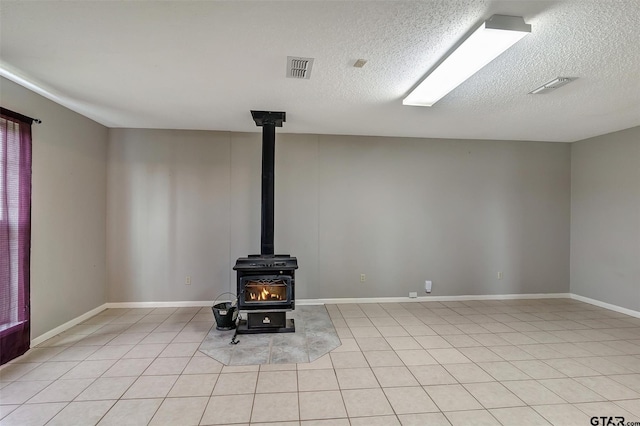 interior details with a textured ceiling and a wood stove