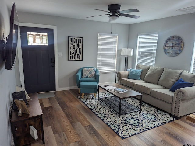 living room featuring ceiling fan, a wealth of natural light, and dark hardwood / wood-style floors