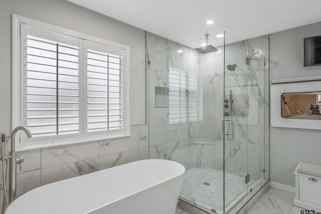 bathroom featuring recessed lighting, a marble finish shower, a freestanding bath, and marble finish floor