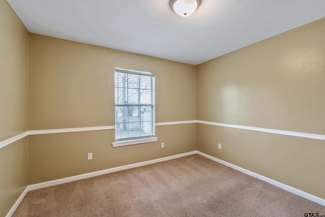 empty room featuring baseboards and carpet floors