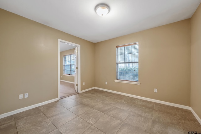 unfurnished room featuring a healthy amount of sunlight and baseboards