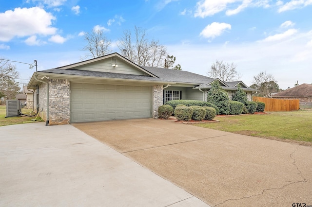 ranch-style house with fence, an attached garage, concrete driveway, a front lawn, and central air condition unit