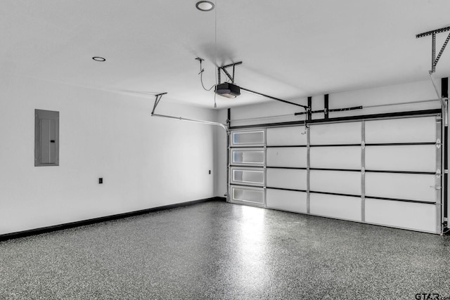 garage featuring electric panel, a garage door opener, and baseboards