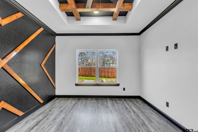 unfurnished room featuring baseboards, coffered ceiling, beam ceiling, and wood finished floors