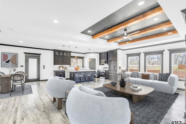 living area with recessed lighting, beam ceiling, light wood-style floors, and crown molding