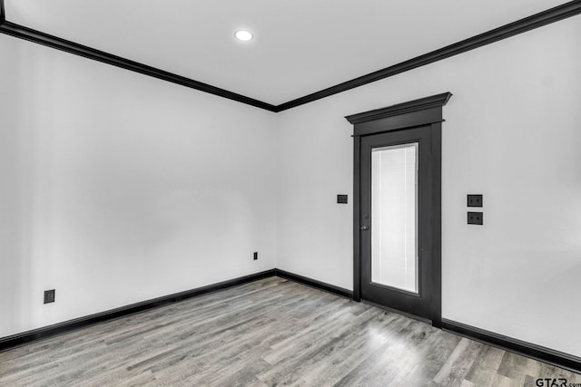 spare room featuring recessed lighting, wood finished floors, baseboards, and ornamental molding