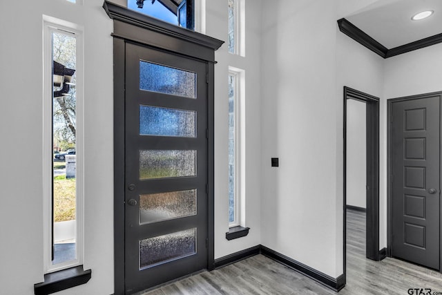 foyer entrance featuring recessed lighting, baseboards, light wood-style floors, and ornamental molding