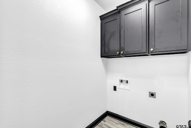 laundry area with wood finished floors, baseboards, hookup for an electric dryer, cabinet space, and washer hookup