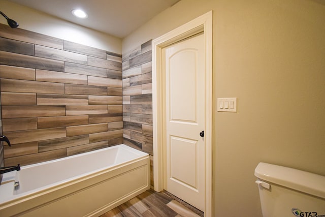 bathroom featuring tub / shower combination, wood finished floors, toilet, and recessed lighting