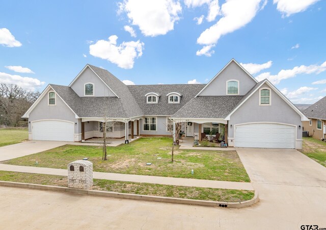 view of front of home with covered porch, roof with shingles, a front lawn, and stucco siding