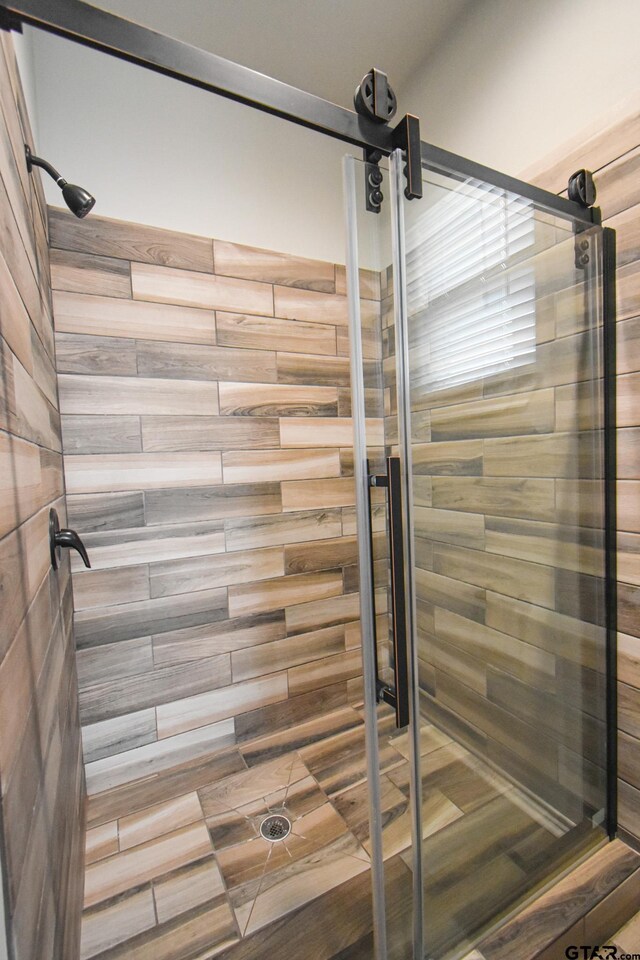 full bathroom featuring a stall shower and baseboards