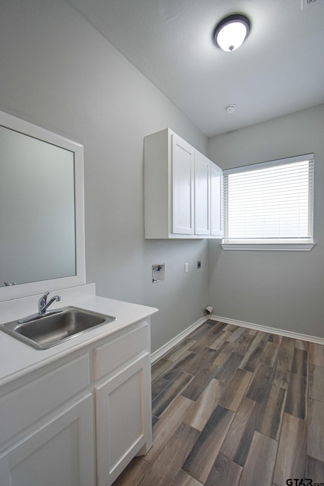 washroom featuring cabinet space, dark wood finished floors, a sink, washer hookup, and electric dryer hookup