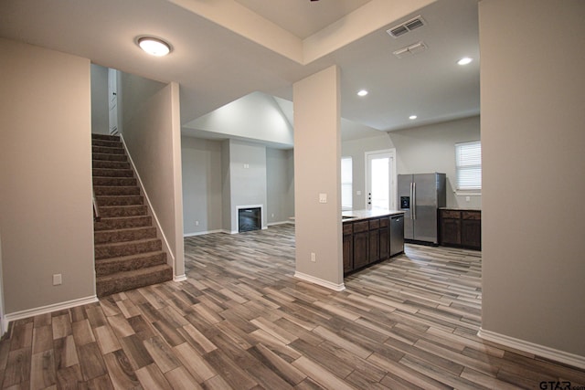 interior space featuring dark brown cabinetry, visible vents, appliances with stainless steel finishes, light countertops, and light wood-type flooring