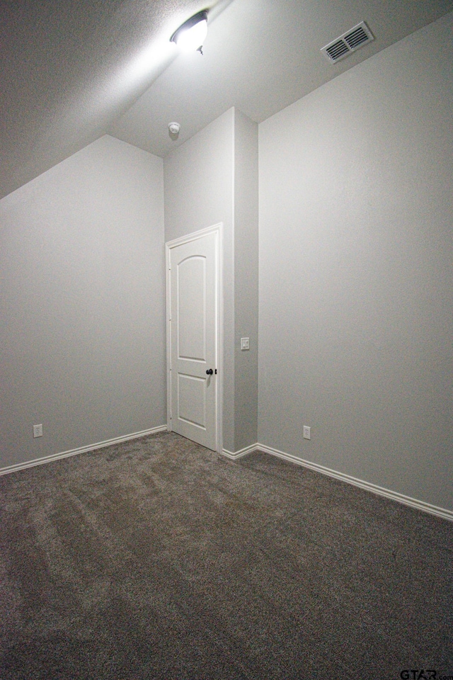 bonus room featuring baseboards, vaulted ceiling, visible vents, and dark colored carpet