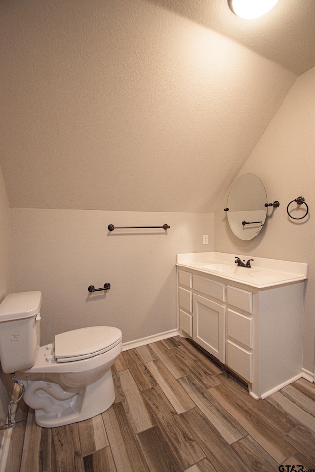 bathroom featuring toilet, a textured ceiling, baseboards, and wood finished floors