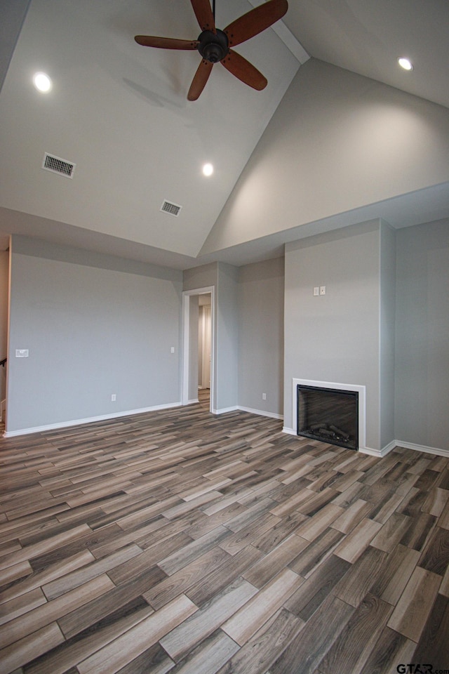 unfurnished living room featuring high vaulted ceiling, a fireplace, visible vents, and wood finished floors