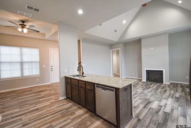 kitchen with dark brown cabinetry, visible vents, dishwasher, open floor plan, and a sink