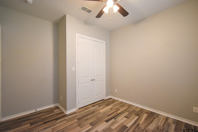 unfurnished bedroom with baseboards, visible vents, and dark wood-style flooring