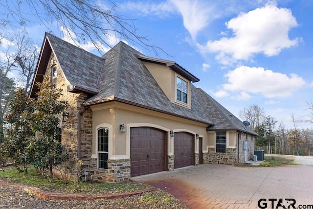 view of front of house featuring a garage and central air condition unit