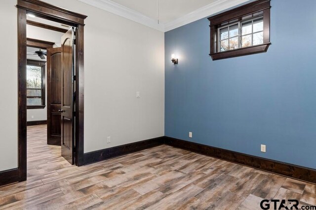 empty room featuring ceiling fan, ornamental molding, and light hardwood / wood-style flooring