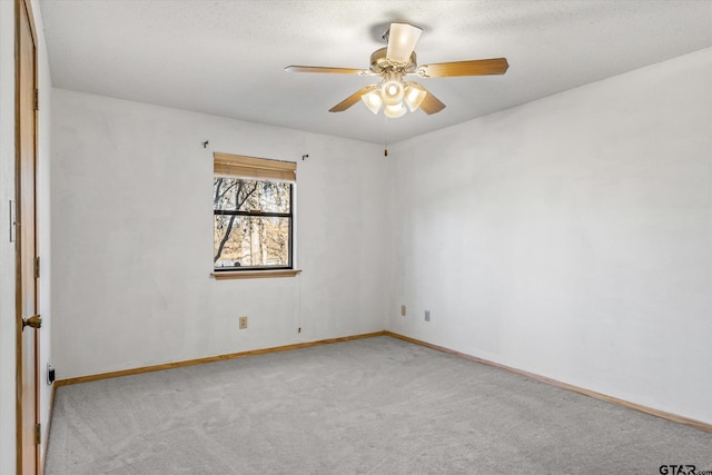 empty room featuring carpet flooring, baseboards, and ceiling fan